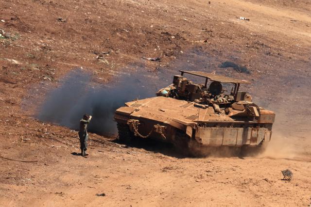 This picture taken from a position in the Upper Galilee in northern Israel shows an Israeli army tank being positioned along the Israel-Lebanon border, on July 1, 2026. Israel's defence minister said on July 1 that Israeli forces would remain in self-proclaimed "security zones" established in Lebanon, Syria and Gaza, without any timeline for withdrawal. (Photo by Jack GUEZ / AFP) / 