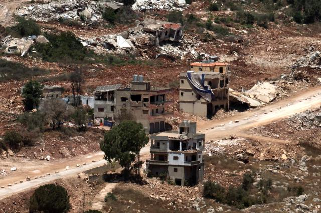 This picture taken from a position in the Upper Galilee in northern Israel shows destroyed buildings in a Lebanese village along the Israel-Lebanon border, on July 1, 2026. Israel's defence minister said on July 1 that Israeli forces would remain in self-proclaimed "security zones" established in Lebanon, Syria and Gaza, without any timeline for withdrawal. (Photo by Jack GUEZ / AFP) / 