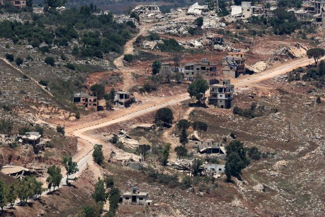 This picture taken from a position in the Upper Galilee in northern Israel shows destroyed buildings in a Lebanese village along the Israel-Lebanon border, on July 1, 2026. Israel's defence minister said on July 1 that Israeli forces would remain in self-proclaimed "security zones" established in Lebanon, Syria and Gaza, without any timeline for withdrawal. (Photo by Jack GUEZ / AFP) / 