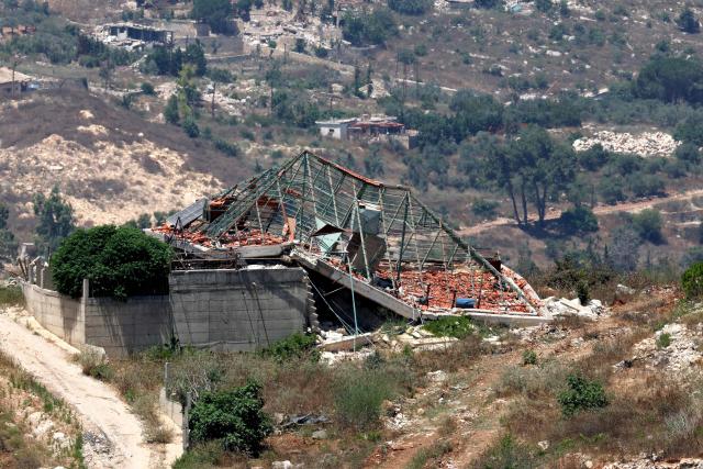 This picture taken from a position in the Upper Galilee in northern Israel shows destroyed buildings in a Lebanese village along the Israel-Lebanon border, on July 1, 2026. Israel's defence minister said on July 1 that Israeli forces would remain in self-proclaimed "security zones" established in Lebanon, Syria and Gaza, without any timeline for withdrawal. (Photo by Jack GUEZ / AFP) / 