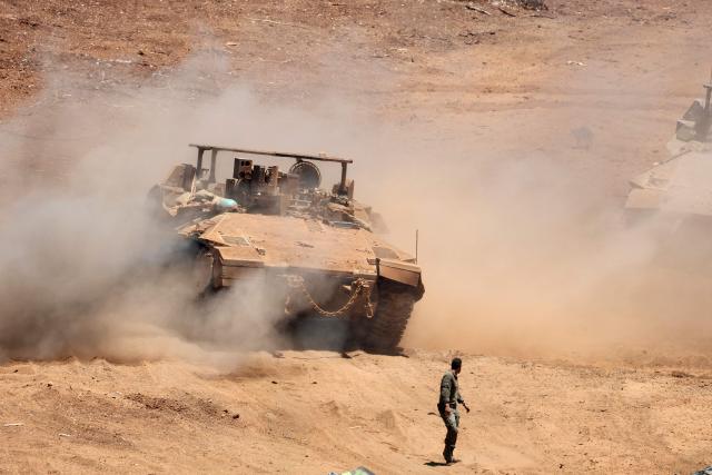 This picture taken from a position in the Upper Galilee in northern Israel shows an Israeli army tank being positioned along the Israel-Lebanon border, on July 1, 2026. Israel's defence minister said on July 1 that Israeli forces would remain in self-proclaimed "security zones" established in Lebanon, Syria and Gaza, without any timeline for withdrawal. (Photo by Jack GUEZ / AFP) / 
