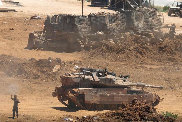This picture taken from a position in the Upper Galilee in northern Israel shows an Israeli army tank being positioned along the Israel-Lebanon border, on July 1, 2026. Israel's defence minister said on July 1 that Israeli forces would remain in self-proclaimed "security zones" established in Lebanon, Syria and Gaza, without any timeline for withdrawal. (Photo by Jack GUEZ / AFP) / 