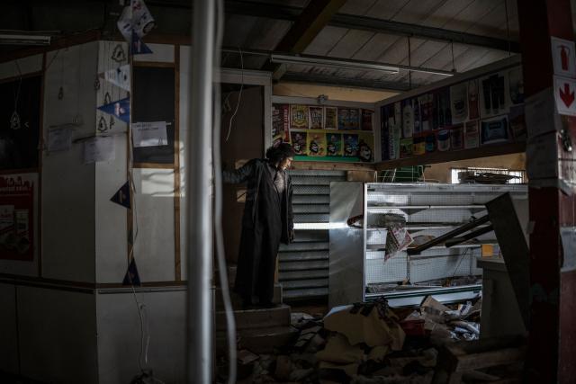One of the managers assesses the damages inside the premises of a looted convenience store in Durban, on July 1, 2026. South Africa faces nationwide anti-immigrant marches after hardline citizen-led groups ordered undocumented foreigners to leave the country by June 30. The unrest has already killed at least four people, with thousands of African migrants fleeing home or huddling in makeshift camps for fear of attack. (Photo by MARCO LONGARI / AFP)