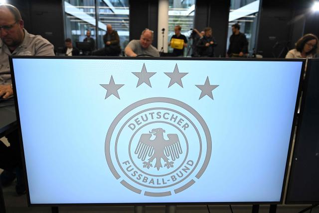 (FILES) This file photo taken on September 22, 2023 shows the logo of the German Football Federation (DFB) during a press conference at the DFB headquarters in Frankfurt, western Germany. Investigators raided Germany's football association headquarters and other locations across the country on July 1, 2026 as part of an investigation into corruption linked to the Euro 2024 tournament. The DFB confirmed that its headquarters in Frankfurt had been targeted. The case involves allegations that employees of German host cities were illegally invited to Euro matches and received tickets on favourable terms from the organisers, police and prosecutors said. (Photo by Kirill KUDRYAVTSEV / AFP)