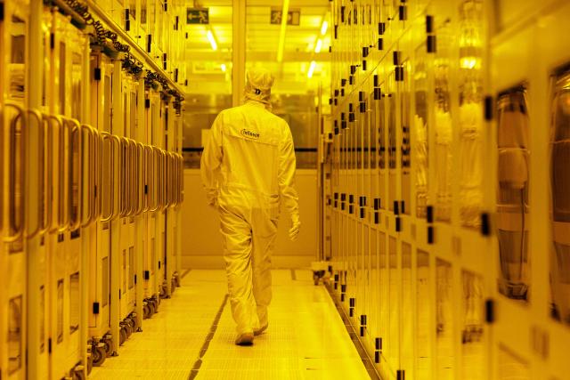 (FILES) An employee walks at the clean room for 300mm wafer manufacturing at the plant of German semiconductor manufacturer Infineon Technologies AG in Dresden, eastern Germany, on June 10, 2026. On July 2, 2026, Infineon will officially open its Smart Power Fab that manufactures power semiconductors as well as analog/mixed-signal-components in Dresden. With an investment of five billion euros, the new facility represents the largest single investment in Infineon's history. (Photo by Jens SCHLÜTER / AFP)