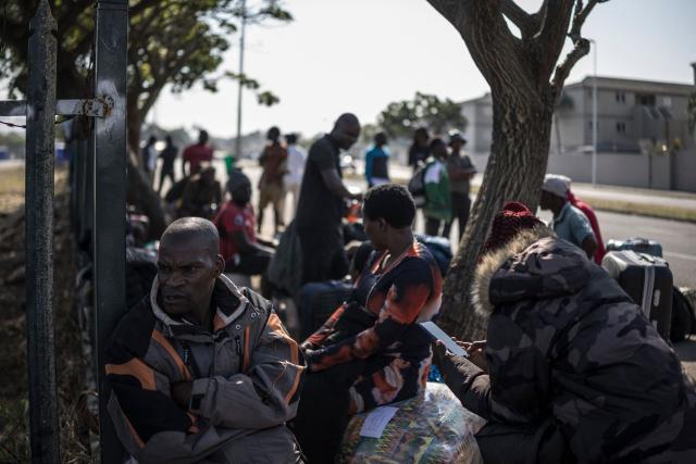 Malawian undocumented migrants sit in a shaded area outside the former Durban Drive in Durban, on July 1, 2026 a day after the expiration of a deadline imposed by anti foreigner groups against those still present in the country. South Africa faces nationwide anti-immigrant marches after hardline citizen-led groups ordered undocumented foreigners to leave the country by June 30. The unrest has already killed at least four people, with thousands of African migrants fleeing home or huddling in makeshift camps for fear of attack. (Photo by MARCO LONGARI / AFP)