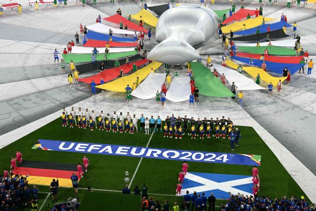 (FILES) This file photo taken on June 14, 2024 shows dancers performing during the opening ceremony of the UEFA Euro 2024 football Championship, prior to the Group A match between Germany and Scotland at the Munich Football Arena in Munich, southern Germany. Investigators raided Germany's football association headquarters and other locations across the country on July 1, 2026 as part of an investigation into corruption linked to the Euro 2024 tournament. The DFB confirmed that its headquarters in Frankfurt had been targeted. The case involves allegations that employees of German host cities were illegally invited to Euro matches and received tickets on favourable terms from the organisers, police and prosecutors said. (Photo by THOMAS KIENZLE / AFP)
