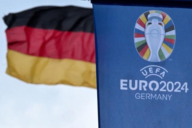 (FILES) In this file photo taken on May 22, 2024 the logo of the UEFA Euro 2024 European Football Championship is pictured on a flag on display in the city centre of Frankfurt am Main, western Germany. Investigators raided Germany's football association headquarters and other locations across the country on July 1, 2026 as part of an investigation into corruption linked to the Euro 2024 tournament. The DFB confirmed that its headquarters in Frankfurt had been targeted. The case involves allegations that employees of German host cities were illegally invited to Euro matches and received tickets on favourable terms from the organisers, police and prosecutors said. (Photo by Kirill KUDRYAVTSEV / AFP)