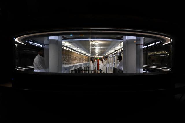 (FILES) Workers and volunteers, pack the Bayeux Tapestry in a crate for transfer to the British Museum, at the Bayeux Tapestry Museum, in Bayeux, northwestern France, on September 18, 2025. Thousands rushed to get tickets on July1, 2026, for the Bayeux Tapestry exhibition in London, with the 11th-century artwork depicting the 1066 Norman conquest of England set to be transported from France for its first showing in the UK, set to be July 11. (Photo by LOU BENOIST / POOL / AFP)