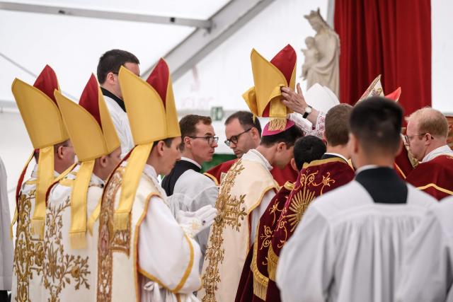 The new consacred bishops receive the mitre during the schismatic consecration of bishops by the traditionalist Catholic Society of Saint Pius X (SSPX) in Econe, western Switzerland, on July 1, 2026. The Society of Saint Pius X consecrated four new bishops on July 1, 2026, in defiance of Pope Leo XIV, who pleaded with the ultra-traditionalist breakaway group to turn back from what he called a "schismatic act" with Rome. (Photo by Fabrice COFFRINI / AFP)