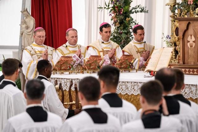(From L) The new traditionalist Catholic consacred bishops Swiss Pascal Schreiber, US' Michael Goldade, French Michel Poinsinet de Sivry and French Marc Hanappier stand during the schismatic consecration of bishops by the traditionalist Catholic Society of Saint Pius X (SSPX) in Econe, western Switzerland, on July 1, 2026. On June 30, 2026, Pope Leo XIV urged the Society to abandon its plan to ordain bishops without Vatican approval, warning it would lead to automatic excommunication. Founded in 1970 in Econe by French bishop Marcel Lefebvre, the Society of Saint Pius X categorically rejects the changes in the Church since the Second Vatican Council. (Photo by Fabrice COFFRINI / AFP)