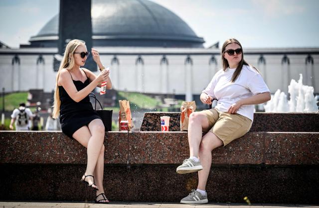 Women have a lunch break near a fountain outside the Museum of the Great Patriotic War (also known as the Victory Museum ) at Poklonnaya Hill in western Moscow on July 1, 2026. Russia's meteorological agency issued a heat warning until July 2 with day temperatures expected to reach 31 degrees Celsius. (Photo by Alexander NEMENOV / AFP)