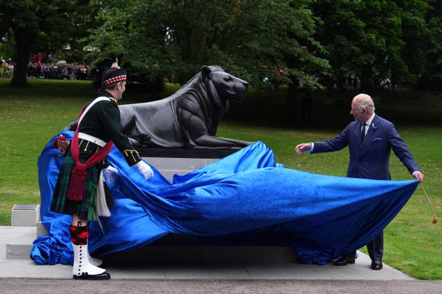 Britain's King Charles III (R), in his role as Colonel-in-Chief of the Royal Regiment of Scotland, is helped by Major General Robert Lindsay, as he unveils a statue to mark the Regiment's 20th anniversary, at West Princes Street Gardens in Edinburgh, Scotland, on July 1, 2026. (Photo by Aaron Chown / POOL / AFP)