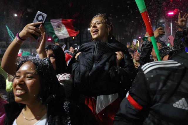 Mexican football fans celebrate a goal of Mexico as they watch the FIFA World Cup 2026 match against Ecuador at the Angel of Independence monument in Mexico City on June 30, 2026. At least three people died during the mass celebrations in Mexico City to mark the national football team’s progress in the 2026 World Cup, the local government reported. (Photo by Claudia Rosel / AFP)