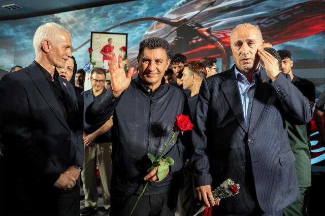Mehdi Taj (R), president of Iran's national football federation, and the men's national team coach Amir Ghalenoei (C) look on during the reception for the team upon their return from the 2026 FIFA World Cup at Tehran's Mehrabad International Airport on July 1, 2026. (Photo by AFP)