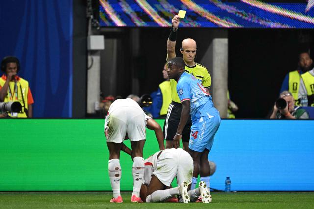 Jordanian referee Adham Makhadmeh shows a yellow card to Congo DR's midfielder #14 Noah Sadiki during the 2026 World Cup round of 32 match football between England and the Democratic Republic of Congo at the Atlanta Stadium in Atlanta on July 1, 2026.  (Photo by ROBERTO SCHMIDT / AFP)