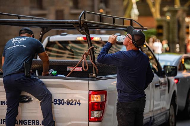 A window washer takes a drink of water during a heat wave in Boston, Massachusetts on July 1, 2026. Tens of millions of Americans sweltered under furnace-like temperatures this week as central and eastern cities hunkered down for a heat wave set to last through the July 4 holiday weekend. Dozens of local temperature records could be broken, the National Weather Service (NWS) warned, with temperatures in many places to surpass 100 degrees Fahrenheit (38 degrees Celsius) and high humidity pushing the heat index as high as 115 degrees. (Photo by Joseph Prezioso / AFP)