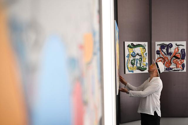 Slovak visual artist Luka Brasse looks at his art works at the temporary POP-UP Gallery at Graben street during his Vienna’s sixth exhibition ‘See Through Me’ in the Austrian capital of Vienna on July 1,2026. Slovak visual artist Luka Brasse, born in 1983 in Northern Slovak town of Dlolny Kubin, is the founder of his own "LukaGraphy" drawing/painting/photography technique. (Photo by Joe KLAMAR / AFP)