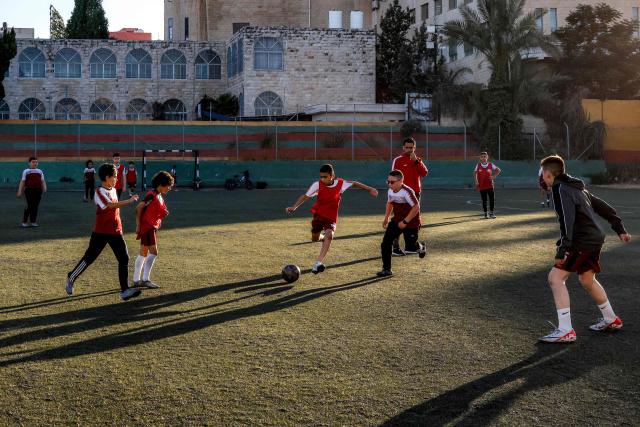 Boys play football at a pitch in the Amaari camp for Palestinian refugees, south of Ramallah in the occupied West Bank, on July 1, 2026. (Photo by Zain JAAFAR / AFP)