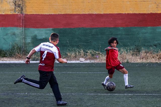 Boys play football at a pitch in the Amaari camp for Palestinian refugees, south of Ramallah in the occupied West Bank, on July 1, 2026. (Photo by Zain JAAFAR / AFP)