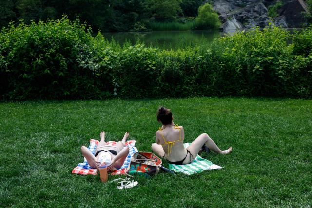 People sunbathe in Central Park during a heatwave in New York City, on July 1, 2026. Tens of millions of Americans sweltered under furnace-like temperatures this week as central and eastern cities hunkered down for a heat wave set to last through the July 4 holiday weekend. Dozens of local temperature records could be broken, the National Weather Service (NWS) warned, with temperatures in many places to surpass 100 degrees Fahrenheit (38 degrees Celsius) and high humidity pushing the heat index as high as 115 degrees. (Photo by kena betancur / AFP)