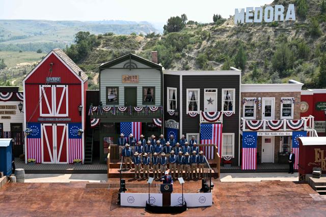 US President Donald Trump delivers remarks onstage, flanked by Rough Riders re-enactors, portraying the 1st United States Volunteer Cavalry, at the Burning Hills Amphitheatre after attending the opening of the Theodore Roosevelt Presidential Library in Medora, North Dakota, on July 1, 2026. (Photo by SAUL LOEB / AFP)