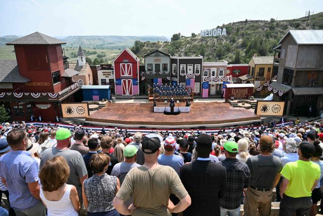 US President Donald Trump delivers remarks onstage, flanked by Rough Riders re-enactors, portraying the 1st United States Volunteer Cavalry, at the Burning Hills Amphitheatre after attending the opening of the Theodore Roosevelt Presidential Library in Medora, North Dakota, on July 1, 2026. (Photo by SAUL LOEB / AFP)
