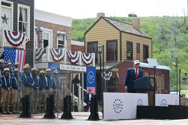 US President Donald Trump delivers remarks onstage, flanked by Rough Riders re-enactors, portraying the 1st United States Volunteer Cavalry, at the Burning Hills Amphitheatre after attending the opening of the Theodore Roosevelt Presidential Library in Medora, North Dakota, on July 1, 2026. (Photo by SAUL LOEB / AFP)