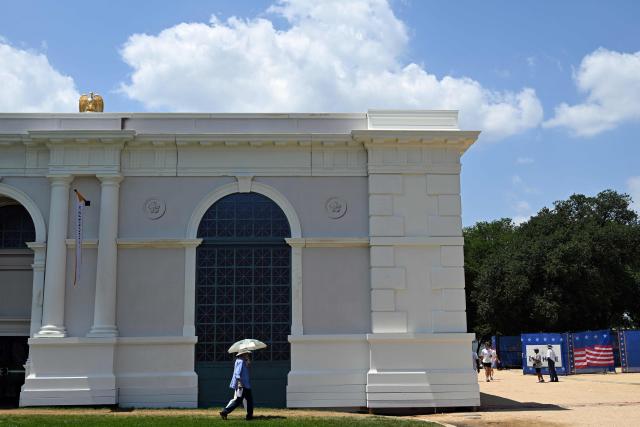 A person uses an umbrella to try to stay cool while visiting "The Great American State Fair" during a heatwave in Washington, DC, on July 1, 2026. Tens of millions of Americans sweltered under furnace-like temperatures this week as central and eastern cities hunkered down for a heat wave set to last through the July 4 holiday weekend. Dozens of local temperature records could be broken, the National Weather Service (NWS) warned, with temperatures in many places to surpass 100 degrees Fahrenheit (38 degrees Celsius) and high humidity pushing the heat index as high as 115 degrees. (Photo by Alex WROBLEWSKI / AFP)