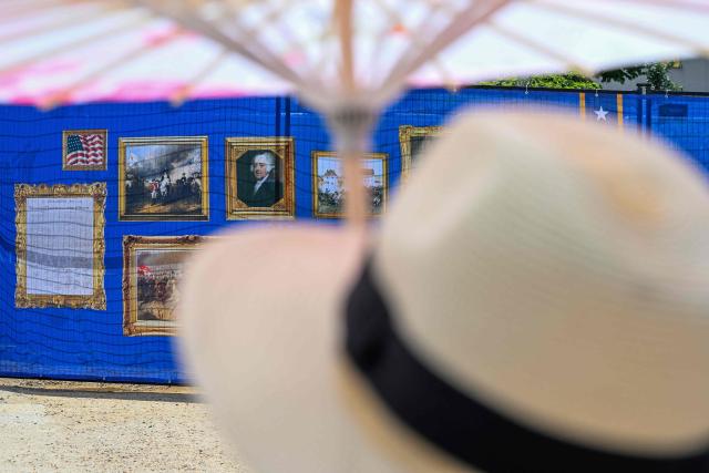 A person uses an umbrella to try to stay cool while visiting "The Great American State Fair" during a heatwave in Washington, DC, on July 1, 2026. Tens of millions of Americans sweltered under furnace-like temperatures this week as central and eastern cities hunkered down for a heat wave set to last through the July 4 holiday weekend. Dozens of local temperature records could be broken, the National Weather Service (NWS) warned, with temperatures in many places to surpass 100 degrees Fahrenheit (38 degrees Celsius) and high humidity pushing the heat index as high as 115 degrees. (Photo by Alex WROBLEWSKI / AFP)