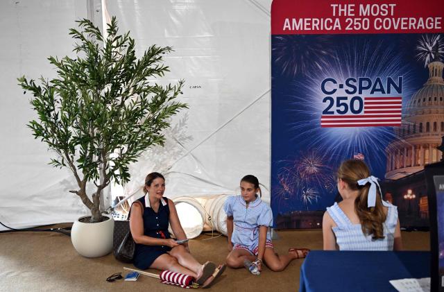 People try to stay cool by the air vents inside a tent as they visit "The Great American State Fair" during a heatwave in Washington, DC, on July 1, 2026. Tens of millions of Americans sweltered under furnace-like temperatures this week as central and eastern cities hunkered down for a heat wave set to last through the July 4 holiday weekend. Dozens of local temperature records could be broken, the National Weather Service (NWS) warned, with temperatures in many places to surpass 100 degrees Fahrenheit (38 degrees Celsius) and high humidity pushing the heat index as high as 115 degrees. (Photo by Alex WROBLEWSKI / AFP)