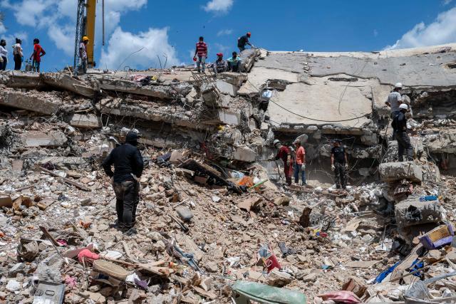 Rescue workers search through debris on a collapsed structure in Playa Grande neighbourhood, La Guaira state, Venezuela, on July 1, 2026, following the June 24 twin earthquakes. Tens of thousands of people urgently need food and shelter in Venezuela due to the devastation from two huge earthquakes that killed more than 1,700 and injured 5,000, the UN said on June 30, 2026, as doctors warned of potential outbreaks of disease. (Photo by Miguel MEDINA / POOL / AFP)