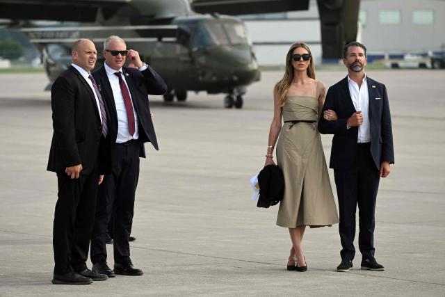 Donald Trump Jr. (R) and his wife Bettina Anderson stand on the tarmac of Bismarck Municipal Airport before boarding Air Force One as they travel with US President Donald Trump to Bismarck, North Dakota, July 1, 2026, following a visit to attend the grand opening of the Theodore Roosevelt Presidential Library. President Trump is on his first trip aboard the Boeing 747-8 that Qatar gifted the United States to use for executive travel. (Photo by SAUL LOEB / AFP)