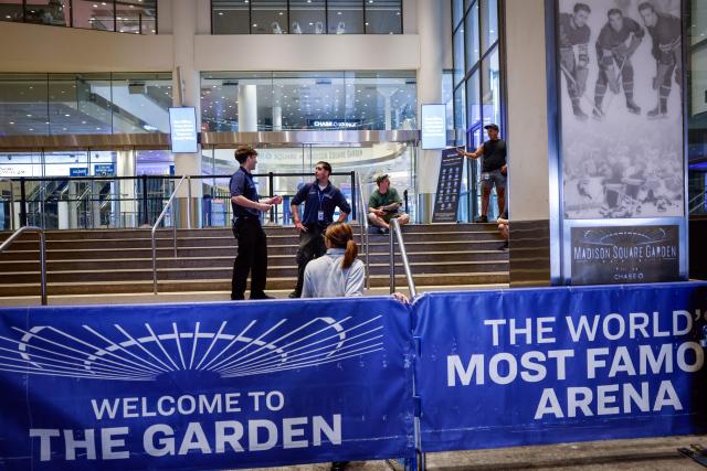 Madison Square Garden employees chat at one of the venue's entrance in New York on July 1, 2026. Increasing signs point to a mega-bash for the A-list celebrity couple Taylor Swift and Travis Kelce at Madison Square Garden this week. Rumors have run rampant for weeks that the 36-year-old pop superstar and the three-time NFL Super Bowl winner, both 36, could wed at the storied sports arena, home to the New York Knicks, the newly crowned NBA champions. (Photo by kena betancur / AFP)