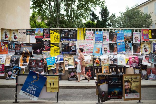 (FILES) Avignon international theater Off festival posters are displayed in Avignon on July 5, 2016. The Avignon festival, a major international theater event, opens July 4, 2026, amidst a desire to celebrate and concerns within a sector affected by threats to creative freedom and budget cuts. At the same time, the Festival Off — with its roughly 1,700 shows — will transform the city into a performing arts marketplace, delighting a loyal audience. (Photo by BERTRAND LANGLOIS / AFP)