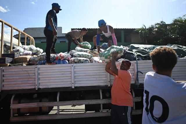 Residents receive and unload aid supplies from a truck in Maiquetia, La Guaira state, Venezuela, on June 29, 2026, following the June 24 twin earthquakes. Hope of finding more survivors faded on July 1 as Venezuela marked a week since twin earthquakes killed almost 2,300 people, while many who lived through the disaster were running desperately short on food. (Photo by Juan BARRETO / AFP)