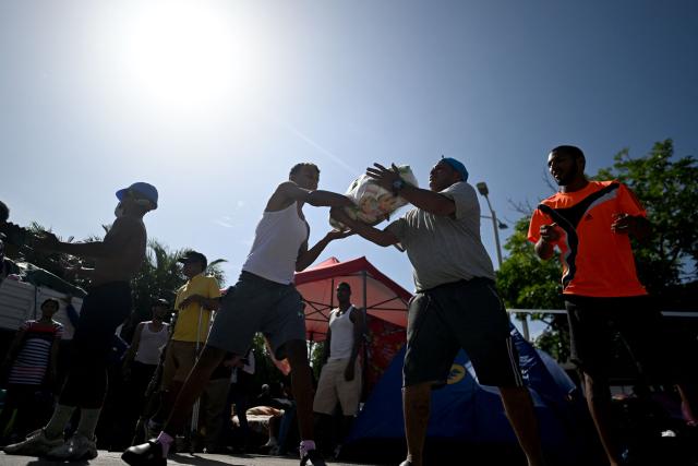 Residents receive and unload food aid from a truck in Maiquetia, La Guaira state, Venezuela, on June 29, 2026, following the June 24 twin earthquakes. Hope of finding more survivors faded on July 1 as Venezuela marked a week since twin earthquakes killed almost 2,300 people, while many who lived through the disaster were running desperately short on food. (Photo by Juan BARRETO / AFP)