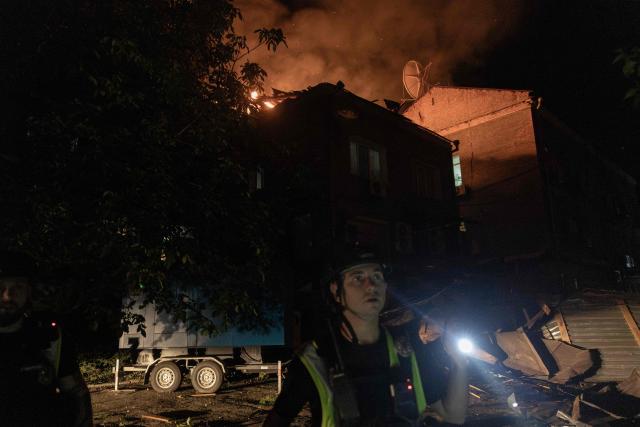 A Ukrainian police officer inspects the area near a burning building struck by a drone following a Russian air attack on Kyiv late on July 1, 2026. AFP journalists in the central and eastern districts of Kyiv heard more than a dozen explosions, as the city's Mayor Vitali Klitschko said on Telegram that "Kyiv is under attack from ballistic missiles and UAVs". (Photo by Roman PILIPEY / AFP)