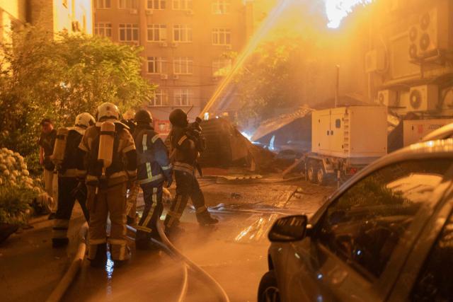 An explosion is seen after a Russian drone strikes a building as Ukrainian firefighters battle a fire in another building previously hit by a drone during a Russian air attack on Kyiv, early on July 2, 2026. AFP journalists in the central and eastern districts of Kyiv heard more than a dozen explosions, as the city's Mayor Vitali Klitschko said on Telegram that "Kyiv is under attack from ballistic missiles and UAVs". (Photo by Roman PILIPEY / AFP)