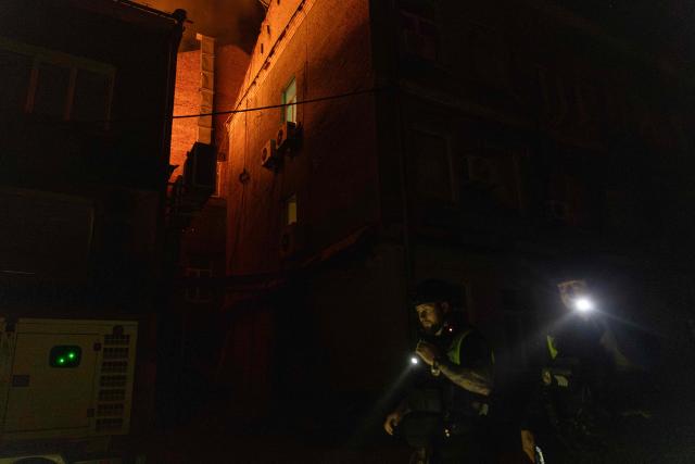 Ukrainian police officers inspect the area near a burning building struck by a drone during a Russian air attack on Kyiv late on July 1, 2026. AFP journalists in the central and eastern districts of Kyiv heard more than a dozen explosions, as the city's Mayor Vitali Klitschko said on Telegram that "Kyiv is under attack from ballistic missiles and UAVs". (Photo by Roman PILIPEY / AFP)