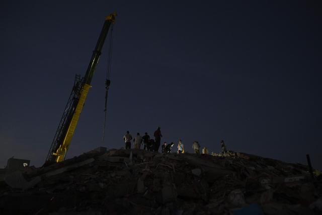 Workers remove debris from a collapsed building as a crane operates in Catia La Mar, La Guaira State, Venezuela on July 1, 2026, following the June 24 twin earthquakes. Hope of finding more survivors faded on July 1 as Venezuela marked a week since twin earthquakes killed almost 2,300 people, while many who lived through the disaster were running desperately short on food. (Photo by Federico PARRA / AFP)