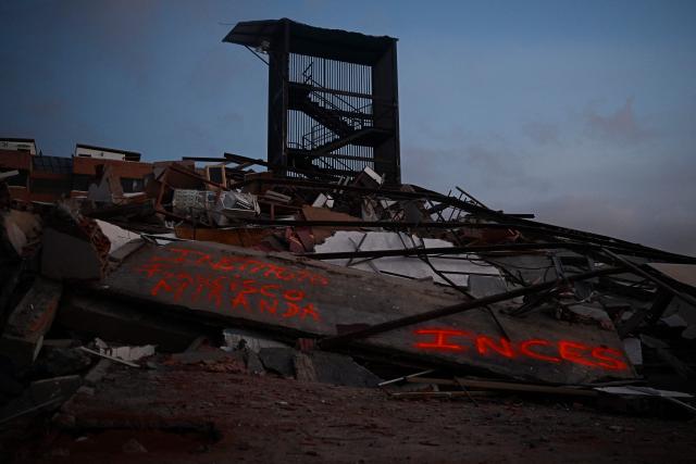 A collapsed building is seen with a stairwell still standing in Catia La Mar, La Guaira State, Venezuela on July 1, 2026, following the June 24 twin earthquakes. Hope of finding more survivors faded on July 1 as Venezuela marked a week since twin earthquakes killed almost 2,300 people, while many who lived through the disaster were running desperately short on food. (Photo by Federico PARRA / AFP)