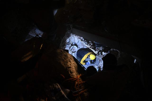 People search for their deceased relatives among the debris of a collapsed building in the Los Corales neighbourhood of Caraballeda, La Guaira State, Venezuela on July 1, 2026, following the June 24 twin earthquakes. Hope of finding more survivors faded on July 1 as Venezuela marked a week since twin earthquakes killed almost 2,300 people, while many who lived through the disaster were running desperately short on food. (Photo by Federico PARRA / AFP)