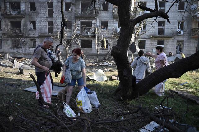 TOPSHOT - Local residents carry their belongings as they leave their damaged residential building following missile strikes on the Ukrainian capital of Kyiv on July 2, 2026, amid the Russian invasion in Ukraine. Russian missile and drone strikes rocked Kyiv early on July 2, killing at least eight people and wounding dozens, after President Volodymyr Zelensky warned that Moscow was preparing a "massive attack". (Photo by Genya Savilov / AFP)