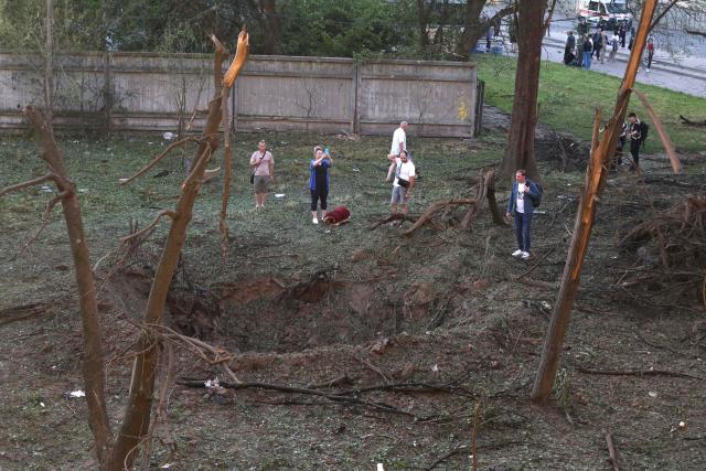 People examine a crater at damaged residential building following missile strikes on the Ukrainian capital of Kyiv on July 2, 2026, amid the Russian invasion of Ukraine. Russian missile and drone strikes rocked Kyiv early on Thursday, setting off fires and wounding at least five people, after President Volodymyr Zelensky warned that Moscow was preparing a "massive attack". (Photo by Serhii Okunev / AFP)