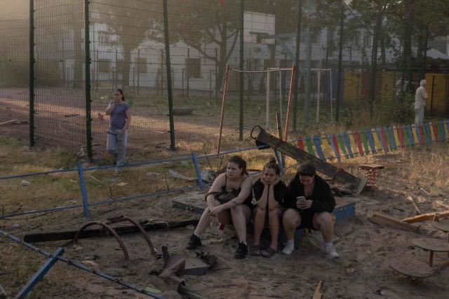 Girls sit at a children's playground as they look at a residential building damaged following a Russian air attack on the Ukrainian capital of Kyiv on July 2, 2026, amid the Russian invasion in Ukraine. Russian missile and drone strikes rocked Kyiv early on July 2, killing at least eight people and wounding dozens, after President Volodymyr Zelensky warned that Moscow was preparing a "massive attack". (Photo by Roman PILIPEY / AFP)