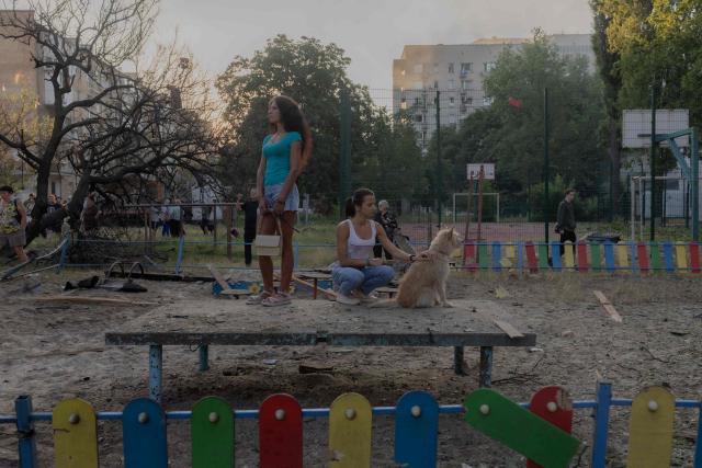 Residents stand with a dog at the site of a residential building damaged following a Russian air attack on the Ukrainian capital of Kyiv on July 2, 2026, amid the Russian invasion in Ukraine. Russian missile and drone strikes rocked Kyiv early on July 2, killing at least eight people and wounding dozens, after President Volodymyr Zelensky warned that Moscow was preparing a "massive attack". (Photo by Roman PILIPEY / AFP)