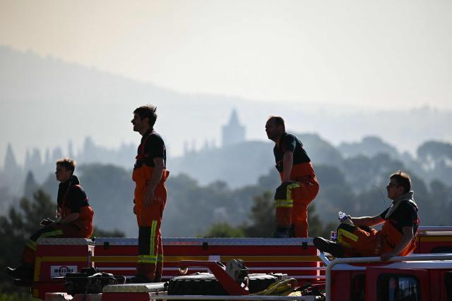 Firefighters look at a wildfire from Pouzols-Minervois, southern France on July 2, 2026. One year after the wildfire in the Corbières massif, the south of France has once again been hit by a large-scale blaze that broke out July 1, 2026 afternoon in the Herault before quickly spreading to the neighboring department of Aude under the combined effect of drought and wind, and is being fought by hundreds of firefighters. (Photo by Lionel BONAVENTURE / AFP)