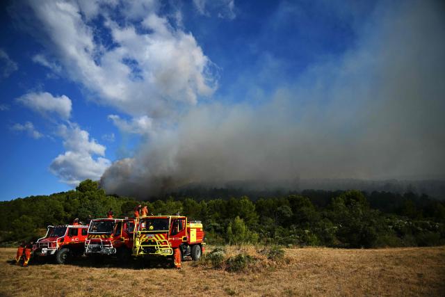 Firefighters look at a wildfire from Pouzols-Minervois, southern France on July 2, 2026. One year after the wildfire in the Corbières massif, the south of France has once again been hit by a large-scale blaze that broke out July 1, 2026 afternoon in the Herault before quickly spreading to the neighboring department of Aude under the combined effect of drought and wind, and is being fought by hundreds of firefighters. (Photo by Lionel BONAVENTURE / AFP)