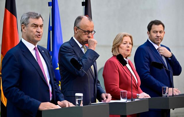 (L-R) German Finance Minister and Vice Chancellor Lars Klingbeil (SPD), German Chancellor Friedrich Merz (CDU), German Minister for Labour and Social Affairs Baerbel Bas (SPD) and Bavaria's State Premier and leader of the conservative Christian Social Union (CSU) Markus Soeder address a press confernce, on July 2, 2026 in the garden of the Chancellery in Berlin, one day after their coalition committee consultations on a major package of reforms. (Photo by Tobias SCHWARZ / AFP)